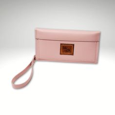 This clutch style wallet is versatile, changing from a clutch to a wristlet by detaching the strap, or tuck the strap inside to keep it out of the way. Two card slots inside, plus 2 zipper pockets and a bill pocket in the back. Magnetic snaps keep the pockets attached together and also closes the top flap. Body is a semi firm pebble grain light pink color, with gray zippers. Size approx. 8" wide x 4.25" high when folded. Pattern is Essentials Leather Wallet by Georgia Girl Stitches Trifold Wallet With Cell Phone Pocket, Clutch Wallets With Cell Phone Pocket For On-the-go, Rectangular Travel Clutch With Snap Closure, Travel Wallet Clutch With Snap Closure, Rectangular Clutch With Snap Closure For Travel, Travel Wallet With Snap Closure, Clutch Style, Versatile Travel Wallet With Snap Closure, Travel Wristlet With Interior Card Slots, Clutch Wallet With Cell Phone Pocket