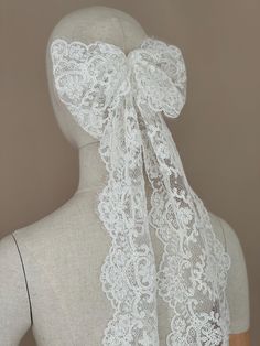 the back of a mannequin wearing a white lace scarf