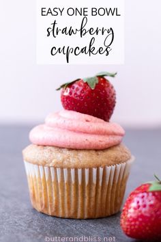 a cupcake with pink frosting and a strawberry on top is sitting next to the words, easy one bowl strawberry cupcakes?