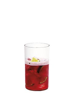 a glass filled with red liquid and lemon wedges