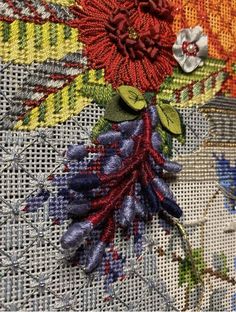 a close up view of some flowers on a piece of fabric with stitching and thread