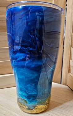 a blue glass sitting on top of a wooden table