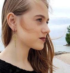 Simple and understated, these modern minimalist earrings are a great go to for everyday wear, to work or a night out. The earrings feature a long golden brass bar that is chin grazing through the middle of a brass geometric circle.  These lightweight earrings hang about 2.75 inches in length while the circle hangs 1.5 inches length. The entire look is topped off with a nickel and lead free french ear wire.For more earrings check out our selection here: https://www.etsy.com/shop/DyNaModuo?section Gold Minimalist Earrings, Drop Earrings Simple, Minimalist Earrings Gold, Brass Bar, Gold Bar Earrings, Jewelry Simple, Geometric Circle, Earrings Geometric, Lightweight Earrings