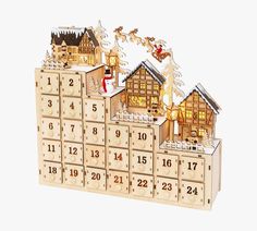 a wooden calendar with houses and santa claus on the top, in front of a white background