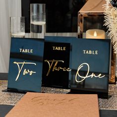 the table name signs are on display for guests to sign their place names in gold ink