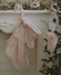 stockings hanging from a fireplace with flowers on the mantle