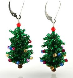 a pair of green christmas tree earrings with red and blue beads on them, hanging from silver hooks