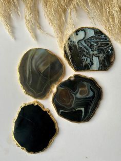 three pieces of agate and black agate with gold trimmings on white surface