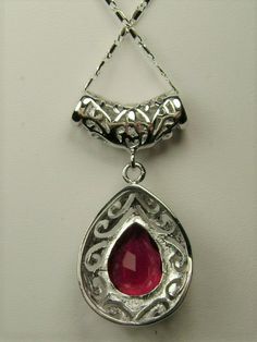 Simulated Red Ruby PendantBig Teardrop Design#P28This is a stunning Victorian inspired pendant necklace. This beautiful necklace is handcrafted from sterling silver. The flawless 6 carat man-made red ruby is a pear cut gemstone. Measurements are 16mm in length and 12mm in width. The 1.5mm sterling silver chain is 18" long (Chain may be different than pictured). The entire pendant is 1-11/16" long by 13/16" wide. The pendant & necklace are marked 925 for sterling silver. Notice the beautiful craf Ruby Pendant Necklace, Ruby Necklace Pendant, Ruby Pendant, Filigree Design, Victorian Jewelry, Red Ruby, Engraved Items, Silver Filigree, Beautiful Necklace