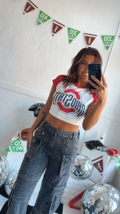 Take your game day style to the next level with our Ohio Crop Baby Tee, perfect for college game day! Its stretchy fabric makes it the perfect option for a comfy game-day look. Ohio crop tee White/Red Baby tee 95% Polyester, 5% Spandex. Cropped Fit Measurements/Sizing: (Approximate. Measured lying flat.) **2-3" stretch throughout. S- Bust 30" Length 14 1/2" M-Bust 32" Length 15" L- Bust 34" Length 15 1/2" Model Specs: Emily is wearing a size small in the photo.How will this item fit you? Check out our MODEL SPECS (Typical Sizing - Karli: S-Size 5/26 - 5ft 2in, Emily: S-Size 3/25 - 5ft 5in, Syd: L/XL- Size 15/ - 5ft 8in)Need help with sizing? No problem! Join our VIP group on Facebook, Everyday Chic Boutique VIP Insiders to chat directly with our team and other customers just like you.Packa White Collegiate Top For Game Day, White Graphic Tee For Game Day, Fitted Cotton T-shirt For Game Day, Sporty Cropped Go-dry Crop Top, Ohio State Crop Top, College Game Days, Red Baby, Everyday Chic, Chic Boutique