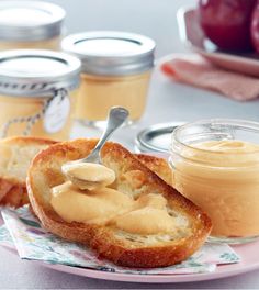 two pieces of bread on a plate with peanut butter and jelly in the jar next to them