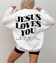 Jesus Loves You Sweatshirt, 1 John 4:19 Shirt, Christian Merch Hoodie For Catholic Mom, Aesthetic Religious Gift, Bible Verse Shirt, RN112 ♥️ WELCOME ♥️ Looking for super soft, comfy, and high-quality clothes for your special days or loved ones? You've come to the right place! We absolutely love what we do and are dedicated to making your shopping experience just perfect. If you have any questions about our products, don't hesitate to reach out. We're here to help and will get back to you as soon as possible! 🔵 HOW TO ORDER  1️⃣Select the t-shirt size 2️⃣ Select the color 3️⃣ If you have, add your personalized designs, enter customization in "Add your personalization" field 4️⃣ Add to cart 5️⃣ Go back and Repeat for each size (to create a set ) ♻️ CARE INSTRUCTIONS  🟢 Wash item inside ou 1 John 4 19, Christian Tshirt Design, Mom Aesthetic, Merch Hoodie, Christian Merch, Christian Tshirt, Bible Verse Shirt, John 4, Jesus Loves You