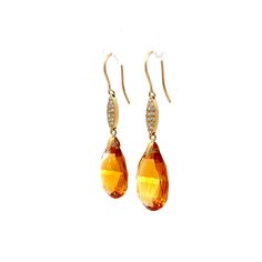 These 18 karat yellow gold drop earrings feature impressive pear-shaped briolette cut citrines, each weighing 14 carats. The rich golden color of the citrine pairs beautifully with the yellow gold, creating a vibrant look. Twelve pave-set diamonds, with VS2 clarity and H color grade, add an extra touch of sparkle. These diamonds, totaling .12 carats, are carefully placed to catch the light from every angle. Ideal for both day and night wear, these earrings offer a blend of elegance and brillianc Luxury Yellow Gold Citrine Earrings, Elegant Faceted Pear-shaped Earrings, Elegant Pear-shaped Faceted Earrings, Luxury Yellow Teardrop Earrings, Luxury Yellow Gold Topaz Earrings, Formal Orange Gemstone Earrings, Elegant Orange Earrings For Formal Occasions, Yellow Gold Briolette Teardrop Earrings For Formal Events, Yellow Gold Briolette Teardrop Earrings For Formal Occasions