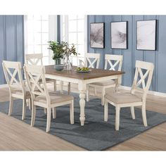 a dining room table with four chairs and a bowl of fruit on top of it