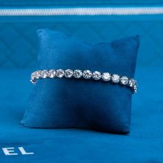 a diamond bracelet sitting on top of a blue pillow