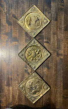 three metal plaques mounted to a wooden wall