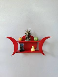 a shelf that has some small pumpkins on it and a statue in the middle