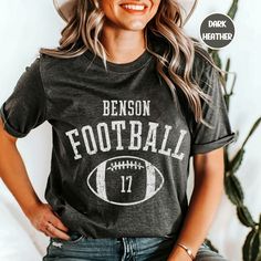 Elevate your Football Game day apparel with this Unisex super soft Customized football shirt.  Customize the front with your school of choice & players number.  These shirts are perfect for men or women. These shirts are made of high-quality cotton.  Thank you for browsing our shop, we hope you find something you enjoy! If there is a shirt color not shown that you want, write in personalization field and we can make it happen. *Check out our other sports options here* https://www.etsy.com/shop/D Customizable T-shirt For Football Season, Varsity T-shirt For College Football Season, Varsity Football Season Fan Gear T-shirt, Varsity T-shirt With Custom Print For Game Day, Varsity Style T-shirt For Football Season Fan Gear, Varsity Style T-shirt For Football Season, Football Season Game Day T-shirt With Team Name, Football Season T-shirt With Team Name For Game Day, Game Day T-shirt With Team Name For Football Season