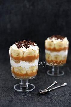 two desserts sitting on top of each other in small glasses with spoons next to them