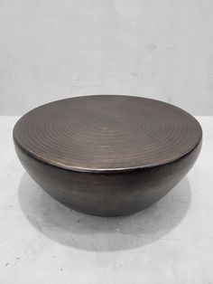 a metal bowl sitting on top of a white table