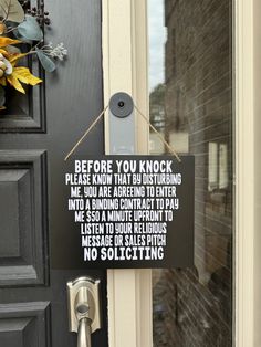 a black door with a sign hanging from it's side