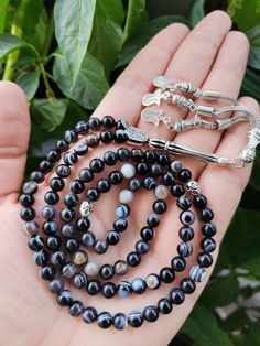 ✔️ This Premium Quality black tasbih made of top quality 6 mm real eye agate (Sulemani Hakik) beads. ✔️ It is a elegant and striking tesbih. ✔️ Natural Color Real Eye Aqiq Rosary ✔️ Natural Black Aqeeq Stone Tasbih ✔️ Each order comes in a special free gift box. ✔️ PLEASE CLICK THE LINK FOR ALL PRAYER BEADS MODELS https://www.etsy.com/shop/GoodJewelsofYazmasal Note: As a natural feature the stones beads may have some variations. 🌟 SHIPPING 🌟 United States (STANDART/DHL ECOMMERCE/USPS): 3-7 bus Adjustable Agate Mala With 8mm Beads, Adjustable Agate Mala With Round Beads, Agate Mala With 108 Beads As Gift, Agate Mala With 108 Beads Gift, Traditional 8mm Agate Beads, Agate Mala With Natural Stones As Gift, Onyx Beads 8mm As A Gift, 8mm Onyx Beads For Gifts, 8mm Agate Beads As Gifts