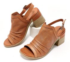 This stacked-heel sandal features a convenient buckle closure, perforated leather upper, and a sophisticated peep-toe detail that's just right for your spring/summer wardrobe. From Spring Step. Spring Slingback Sandals With Buckle Closure And Closed Toe, Spring Closed Toe Slingback Sandals With Buckle, Open Toe Sandals With Perforations, Perforated Open Toe Sandals, Spring Round Toe Sandals With Perforations, Open Toe Perforated Sandals For Summer, Spring Perforated Round Toe Sandals, Summer Open Toe Sandals With Perforations, Spring Leather Heels With Perforations