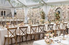 the tables are set up with white linens and floral centerpieces on them