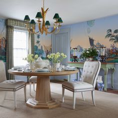 a dining room table with chairs and a chandelier hanging from it's ceiling