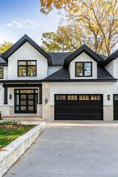 a large white house with black garage doors