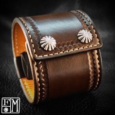 "This Brown leather cuff bracelet is Saddle inspired and made using fine Vegetable tanned leather lined in calfskin. It is hand dyed a beautiful saddle brown, stamped, hand stitched and braided with black kangaroo lace! It uses 2 beautiful native conchos snaps for the closure. I'll need your wrist size for this cuff! Please use the instructions in the pics above! - 2.25\" wide - Fine workmanship - Unique FM design Thanks for checking out my work! I use a fine hand in my work bridging the gap bet Hand-tooled Leather Cuff Bracelet, Classic Handmade Leather Cuff Bracelet, Handmade Custom Leather Bracelet, Luxury Brown Leather Cuff Bracelet, Brown Hand-stitched Leather Bracelet, Leather Concho Cuff Bracelet, Brown Leather Concho Bracelet, Hand Tooled Leather Cuff Bracelet, Leather Cuff Bracelet With Concho