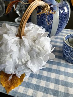 a blue and white checkered table cloth with a vase filled with flowers on it