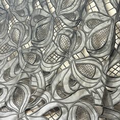 an intricate design is shown on the side of a piece of fabric with mesh netting