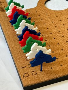 a wooden board with several pieces of plastic elephant on it and numbers in the middle