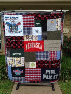 a quilt is hanging on the side of a house