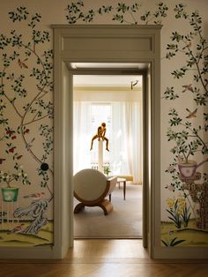 an open door leading to a living room with wallpaper