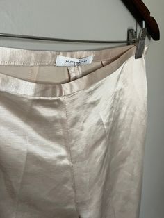 "Super gorgeous shiny trousers in a pearlised white/beige. Mid rise, straight/wide leg.  Label: Josie Natori Condition: Very Good, no issues Size: Small Fabric: Not listed, feels like a structured poly satin Measurements: Waist: 29\" Hip: 38\" Front Rise: 10\" Inseam: 35\"" Fitted Silk Cream Bottoms, Cream Silk Bottoms For Spring, Beige Silk Wide Leg Bottoms, Spring Silk Cream Bottoms, Spring Cream Silk Bottoms, Elegant Beige Silk Pants, Cream Evening Trousers, Beige Satin Bottoms For Spring, Elegant Beige Satin Bottoms