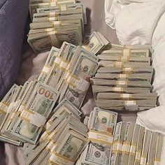 a pile of money sitting on top of a bed