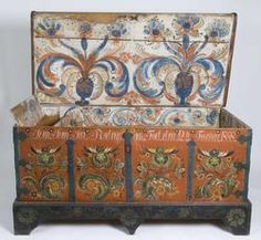 an old wooden trunk with painted designs on the top and bottom, sitting in front of a white background