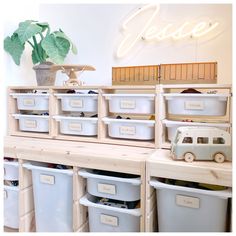 several storage bins are stacked on top of each other in front of a neon sign