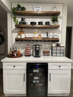 a coffee bar with white cabinets and open shelves