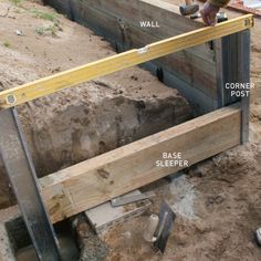 a man is working on the foundation of a house that's being built with wood and metal