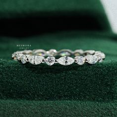 a diamond ring sitting on top of a green velvet