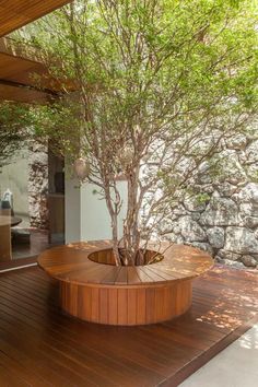 a wooden deck with a tree in the middle and an outdoor hot tub next to it