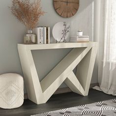 a white console table with books and vases on it