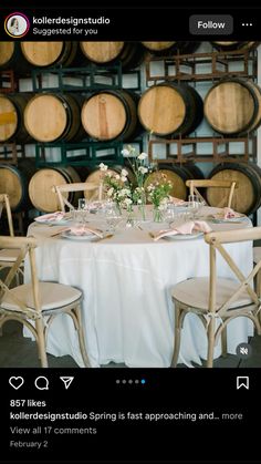 an image of a table setting with wine barrels in the background and flowers on top