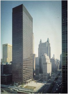 an aerial view of skyscrapers in the city with cars driving on the street below