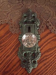 an old fashioned door handle on a wooden table with laces around it and a glass knob