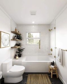 a white bathroom with black and gold accents