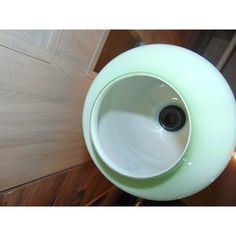 a white sink sitting on top of a wooden floor next to a wall mounted faucet